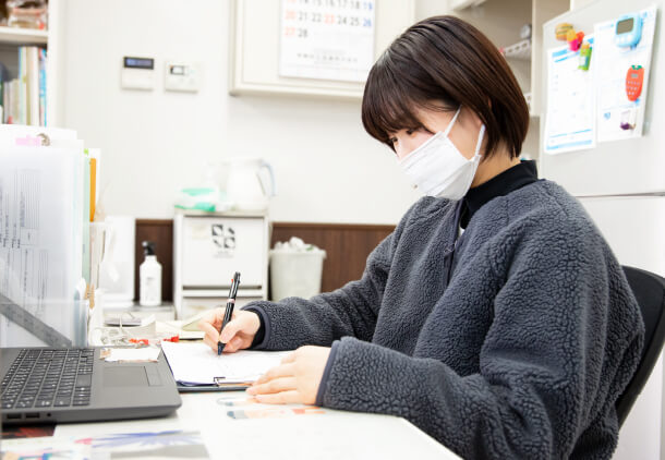 その日の作業内容の報告書等の書類作成を行っている槻木さん